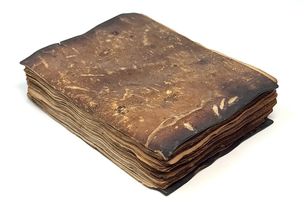Stiff brown leather cover and edges of the loose manuscript leaves.